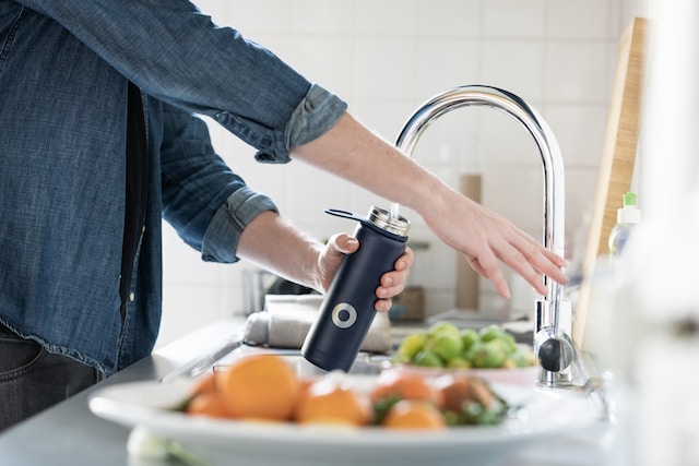 man filling water bottle wit hwater